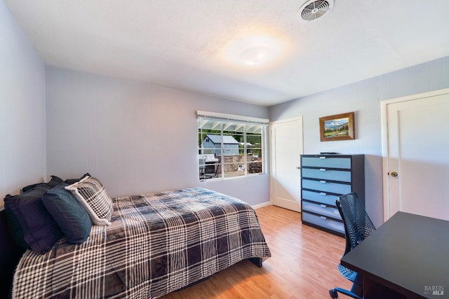 bedroom featuring wood finished floors and visible vents