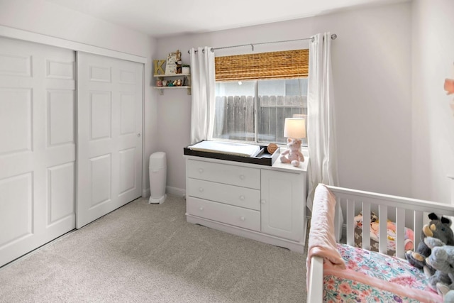 bedroom with light colored carpet, a crib, and a closet