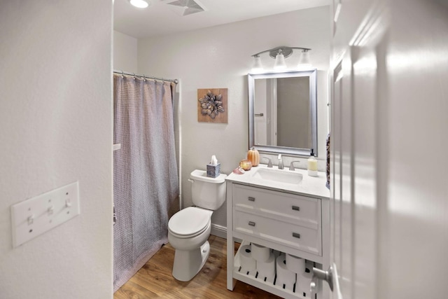 bathroom with visible vents, curtained shower, wood finished floors, vanity, and toilet