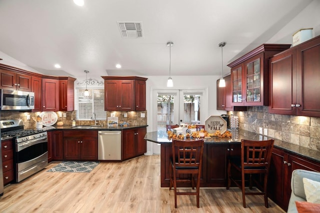 kitchen featuring visible vents, appliances with stainless steel finishes, tasteful backsplash, dark brown cabinets, and a sink