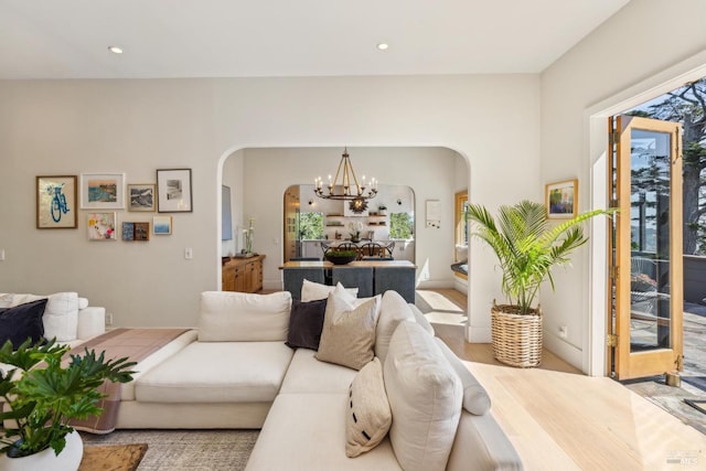 living room with arched walkways, recessed lighting, and a chandelier