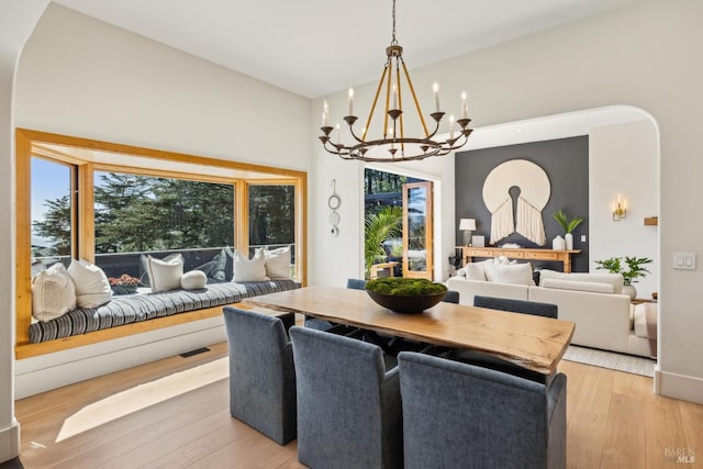 dining area with an inviting chandelier, visible vents, and light wood-type flooring