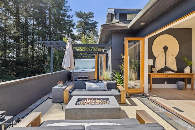 view of patio / terrace featuring a hot tub, a deck, and an outdoor fire pit