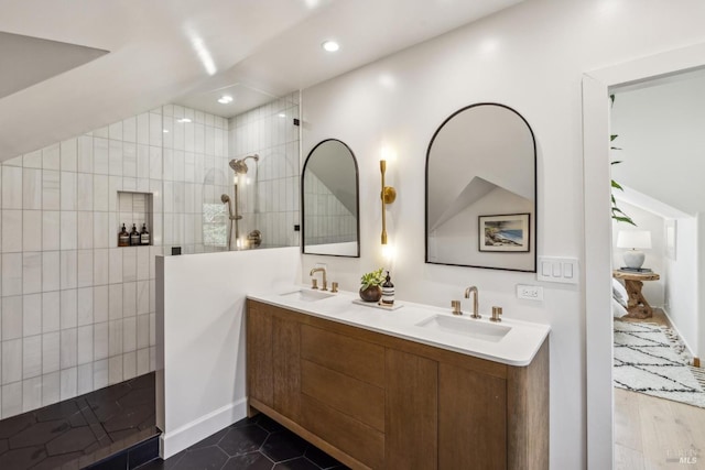 full bath with double vanity, a walk in shower, recessed lighting, and a sink