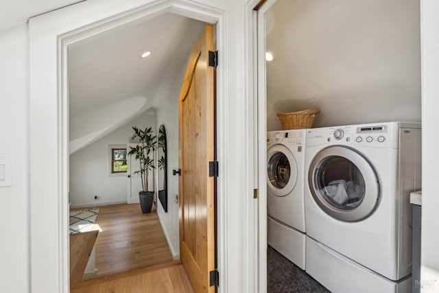 clothes washing area with separate washer and dryer, laundry area, light wood-style flooring, and baseboards