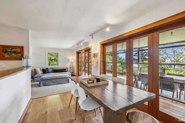 dining space featuring track lighting and light wood-style floors