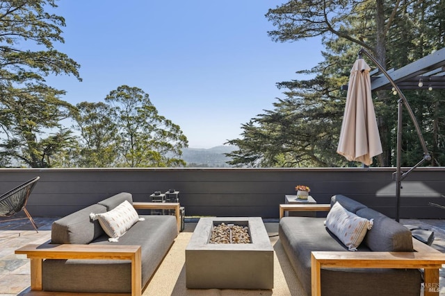 view of patio / terrace featuring a mountain view and an outdoor living space with a fire pit