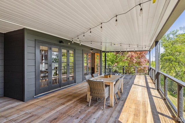 wooden terrace with french doors and outdoor dining space