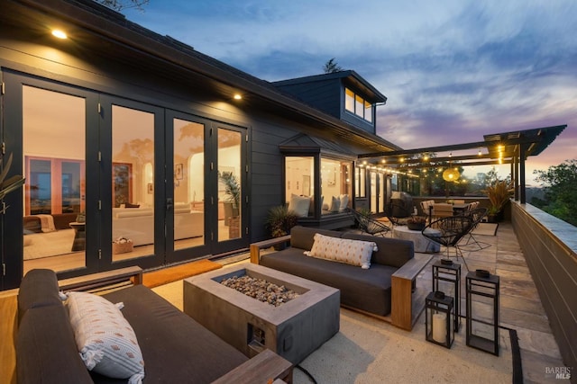view of patio featuring an outdoor living space with a fire pit and french doors