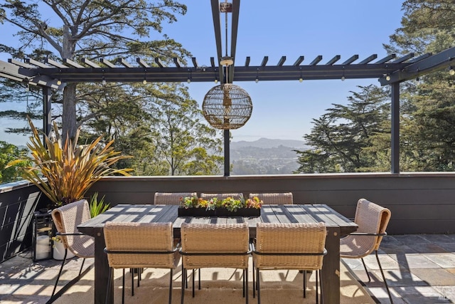 view of patio / terrace with a pergola, outdoor dining area, and a mountain view
