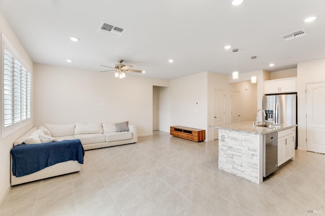 living room with a ceiling fan, recessed lighting, visible vents, and light tile patterned flooring
