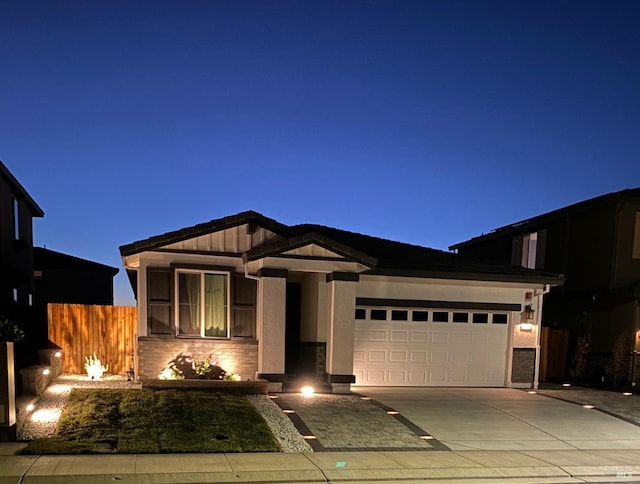 view of front of property featuring concrete driveway, a garage, and fence