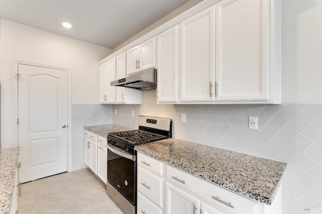 kitchen featuring light stone countertops, under cabinet range hood, stainless steel gas range, light tile patterned floors, and white cabinetry