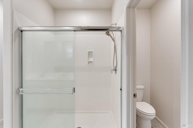 full bath featuring toilet and a stall shower