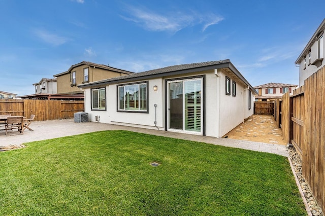 back of property with a lawn, a patio, stucco siding, central AC unit, and a fenced backyard