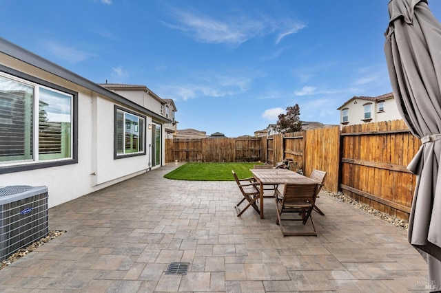 view of patio with cooling unit, outdoor dining area, and a fenced backyard