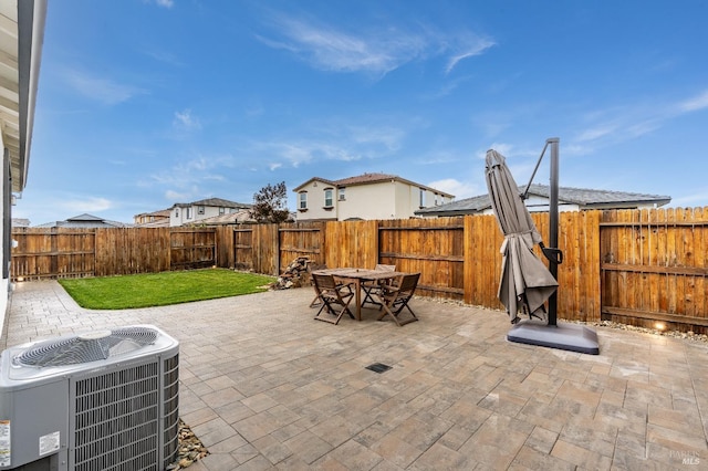 view of patio / terrace with central AC unit, outdoor dining area, and a fenced backyard