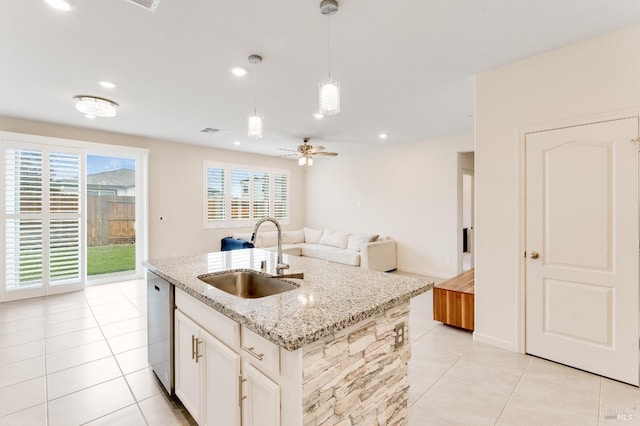 kitchen featuring a sink, visible vents, light tile patterned floors, stainless steel dishwasher, and hanging light fixtures