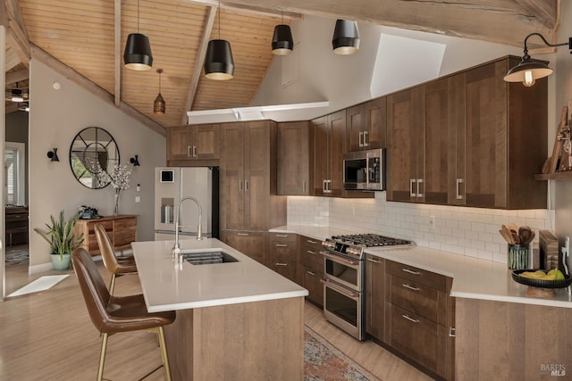 6200 Burnside Rd, Sebastopol, CA 95472 - kitchen featuring stainless steel appliances, a sink, backsplash, light wood-style flooring, and beamed ceiling