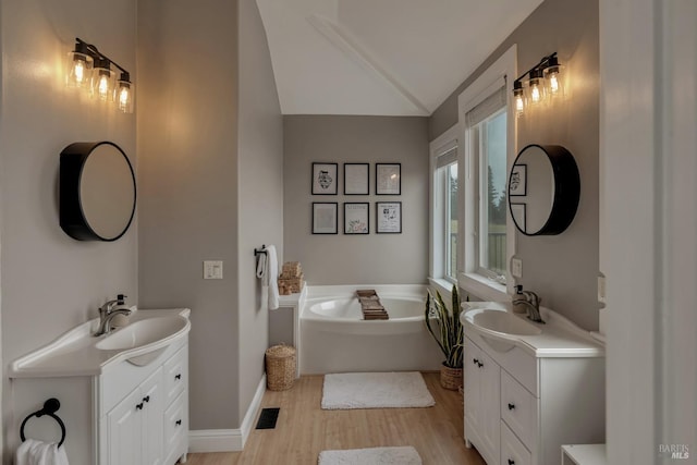 6200 Burnside Rd, Sebastopol, CA 95472 - full bath featuring lofted ceiling, wood finished floors, a garden tub, two vanities, and baseboards