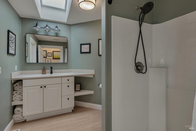 6200 Burnside Rd, Sebastopol, CA 95472 - full bathroom with wood finished floors, baseboards, a skylight, a shower, and vanity