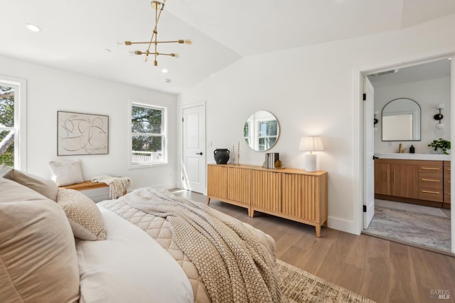 bedroom with connected bathroom, a notable chandelier, light wood-type flooring, lofted ceiling, and recessed lighting