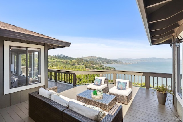 wooden terrace featuring an outdoor living space and a water and mountain view