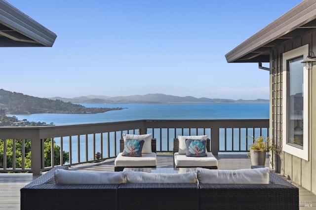 wooden terrace featuring an outdoor living space and a water and mountain view
