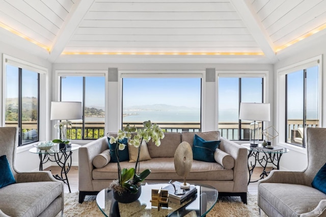 sunroom featuring a water view and beam ceiling
