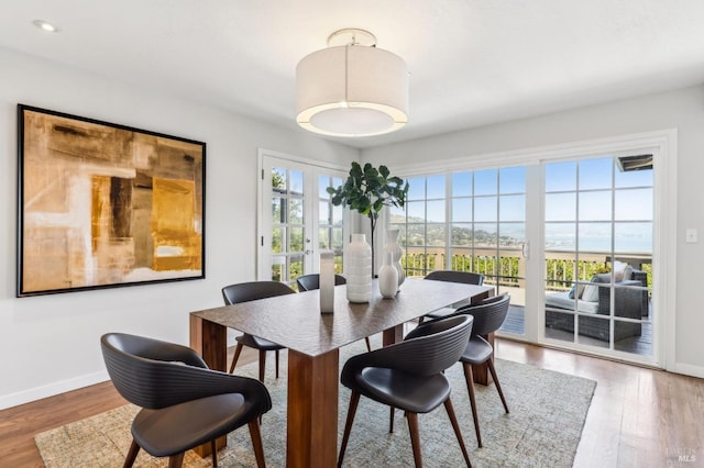 dining room with french doors, recessed lighting, baseboards, and wood finished floors