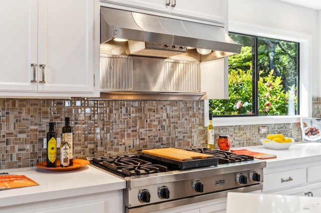 kitchen featuring stainless steel gas cooktop, light countertops, white cabinetry, tasteful backsplash, and under cabinet range hood