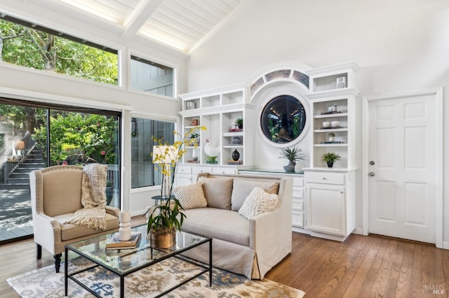interior space featuring beam ceiling, wood finished floors, and high vaulted ceiling