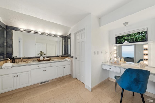 bathroom with visible vents, a sink, vaulted ceiling, and double vanity