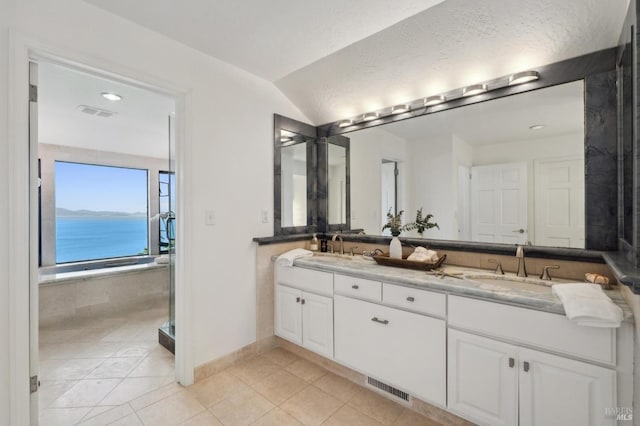 full bath with a sink, tile patterned floors, double vanity, and visible vents