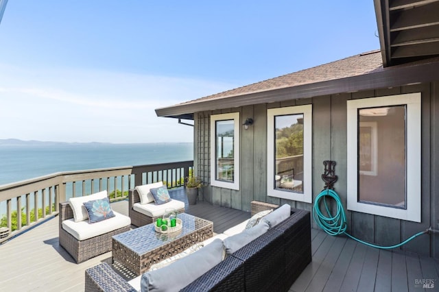 wooden deck with an outdoor living space and a water view