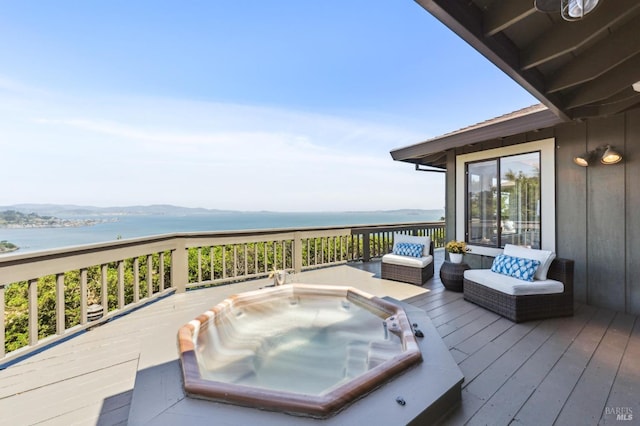 wooden terrace featuring a water view and hot tub deck surround