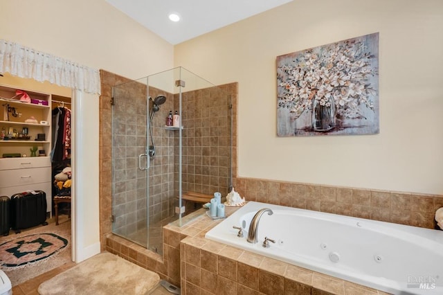 full bathroom with a whirlpool tub, a walk in closet, tile patterned flooring, and a shower stall