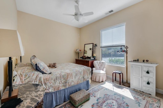 bedroom with light colored carpet, baseboards, visible vents, and ceiling fan