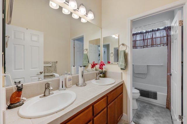 bathroom featuring double vanity, toilet, visible vents, and a sink