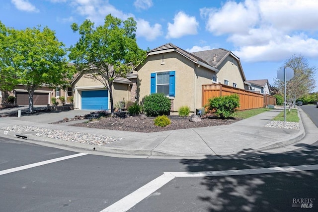 view of front of house featuring stucco siding, fence, and a tile roof