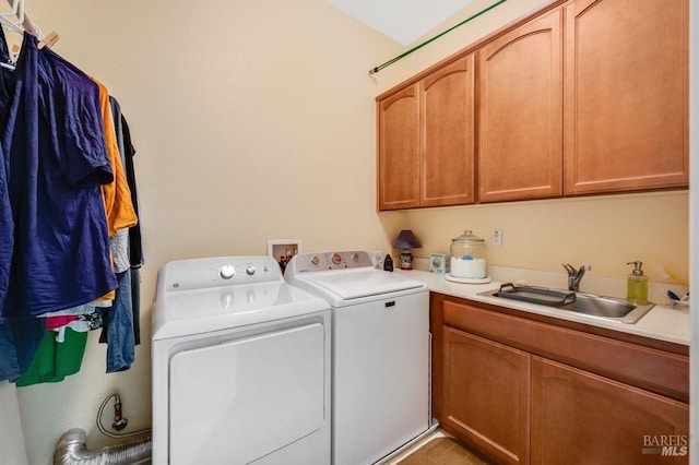 laundry room featuring cabinet space, a sink, and washer and clothes dryer
