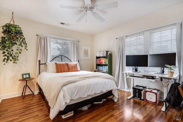 bedroom with a ceiling fan, baseboards, visible vents, and wood finished floors