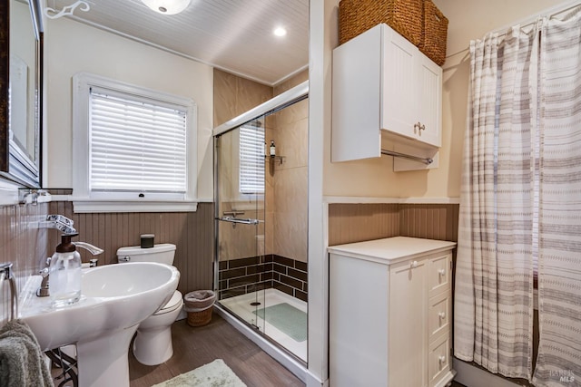 full bath with a sink, toilet, a wainscoted wall, a shower stall, and wood finished floors