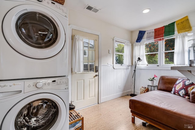 laundry room with stacked washer / drying machine, laundry area, wainscoting, recessed lighting, and visible vents