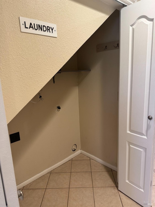 laundry room featuring light tile patterned floors and baseboards