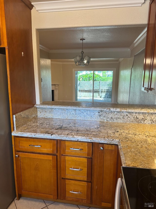 kitchen featuring brown cabinetry, a notable chandelier, ornamental molding, and light stone countertops