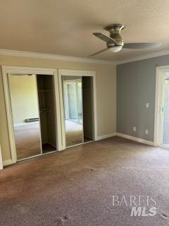 unfurnished bedroom with crown molding, a ceiling fan, baseboards, and carpet floors