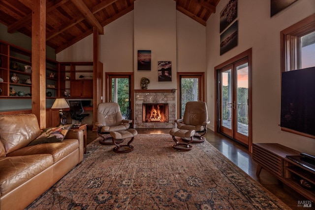 living room featuring wooden ceiling, plenty of natural light, and a lit fireplace