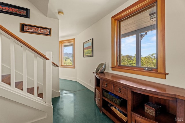 interior space featuring concrete flooring, baseboards, and a wealth of natural light
