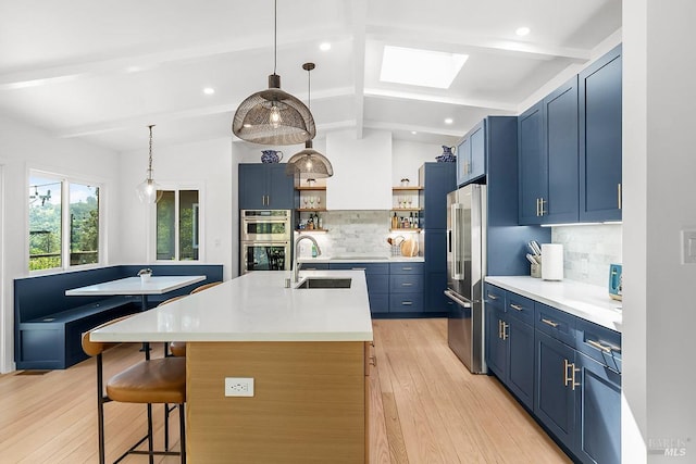 5 Oak Springs Dr, San Anselmo, CA 94960 - kitchen featuring blue cabinetry, open shelves, a center island with sink, a sink, and stainless steel appliances